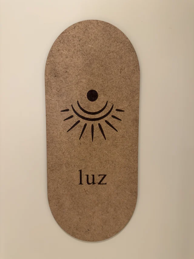 Detalle del estudio: una placa de madera con un sol y la palabra luz