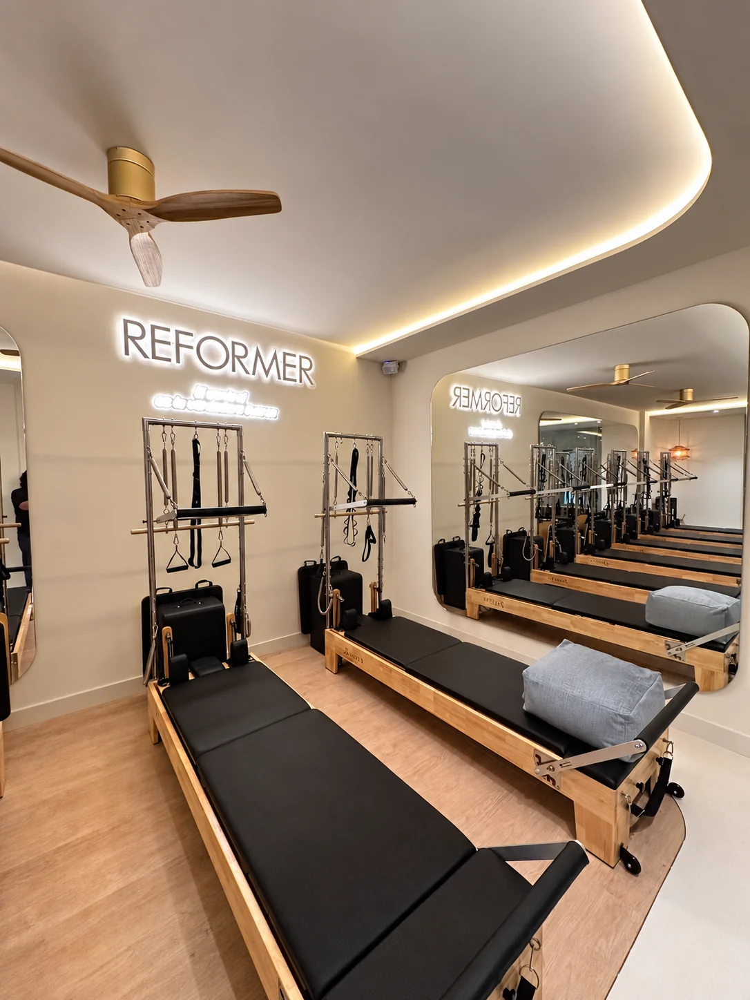 Sala de Reformer de Origen con máquinas de madera, espejos y luz cálida